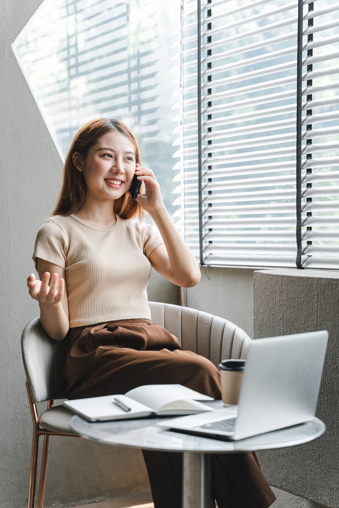 Asian girl. Beautiful woman enjoys talking on the phone in the house by the window.